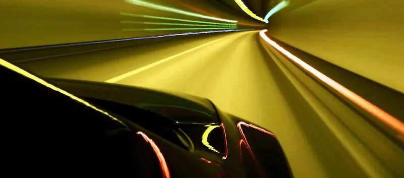 Car driving fast through a tunnel.
