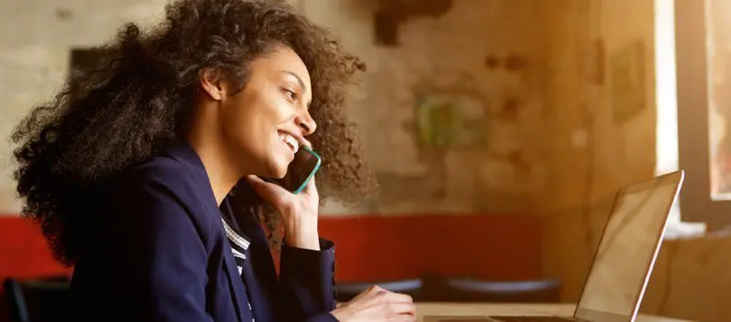 Lady on phone using a laptop.