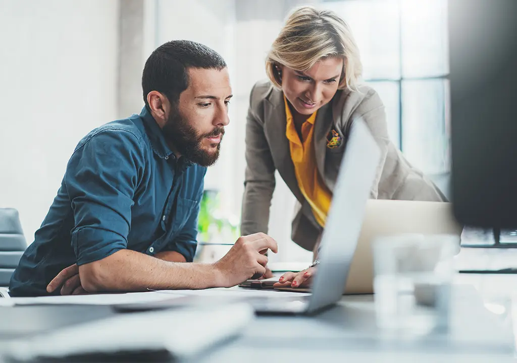 Man and woman looking at a laptop.