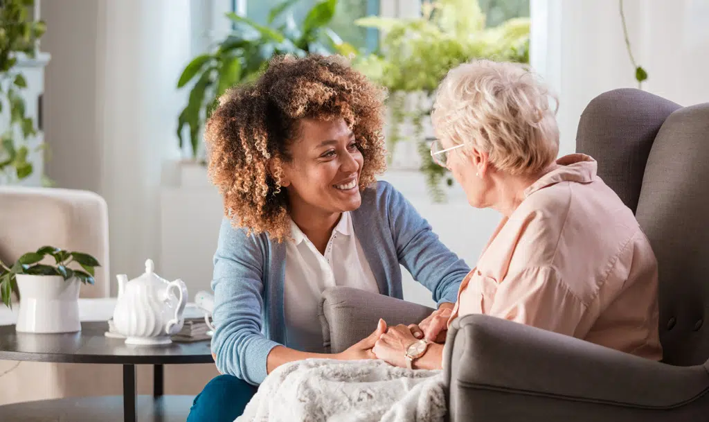Nurse looking after elderly lady in a care home.