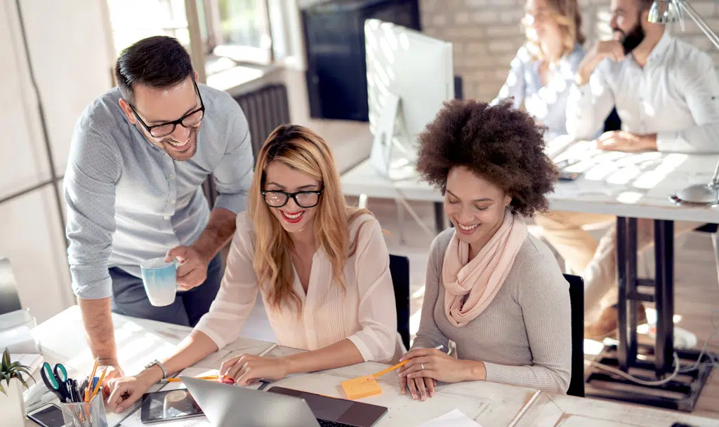 Three people looking at marketing reports.