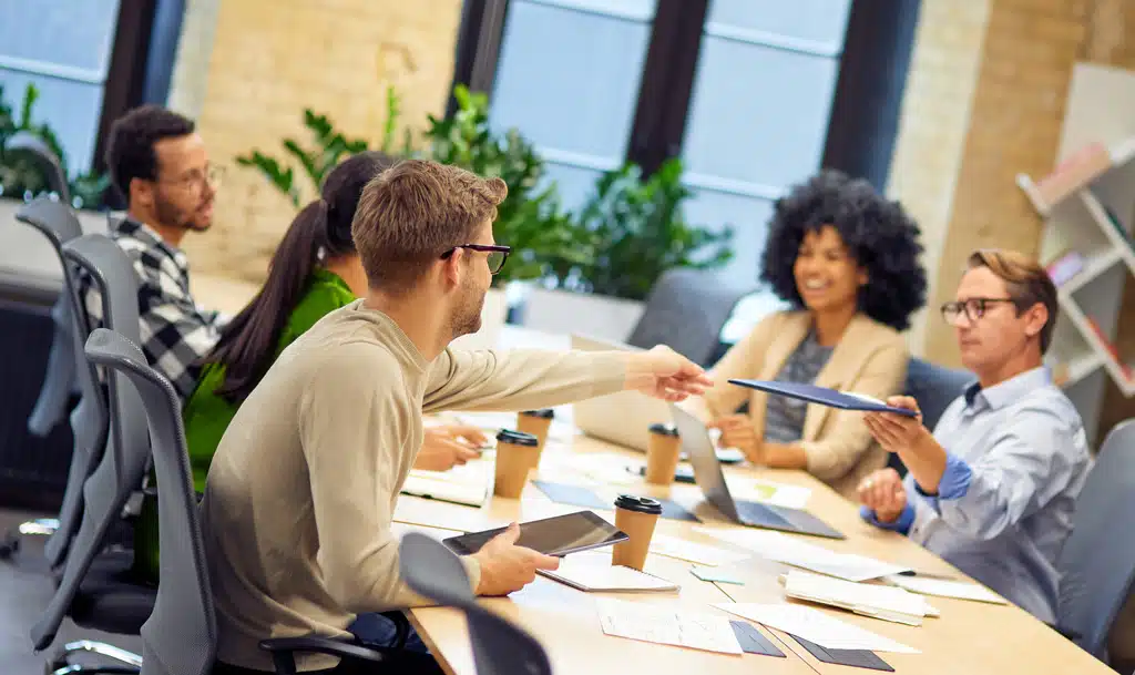 Group of marketers aroun a table discussing analytics.