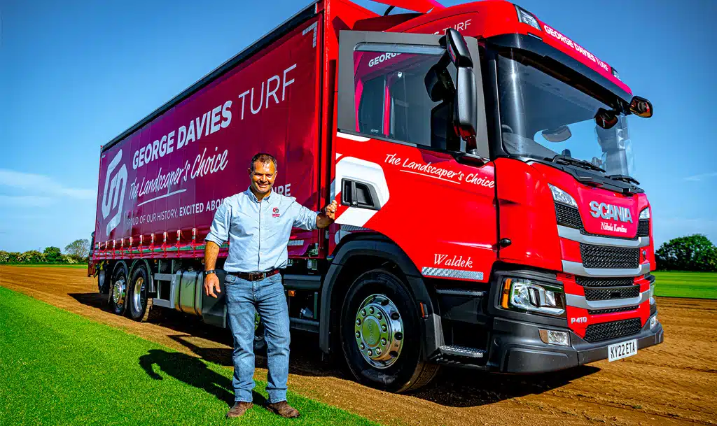 George Davies standing in front of one of the company's trucks.