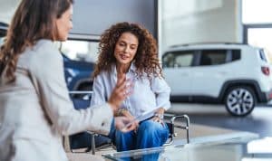 Two ladies in a car dealership.