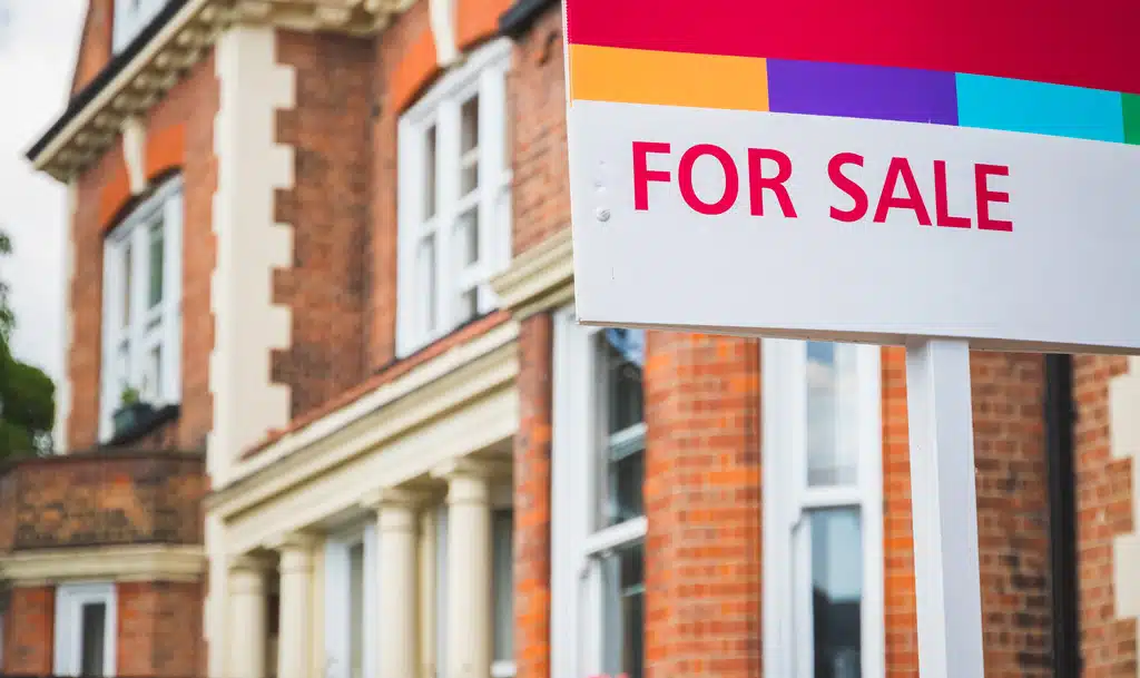 A property with a 'For sale' sign outside.
