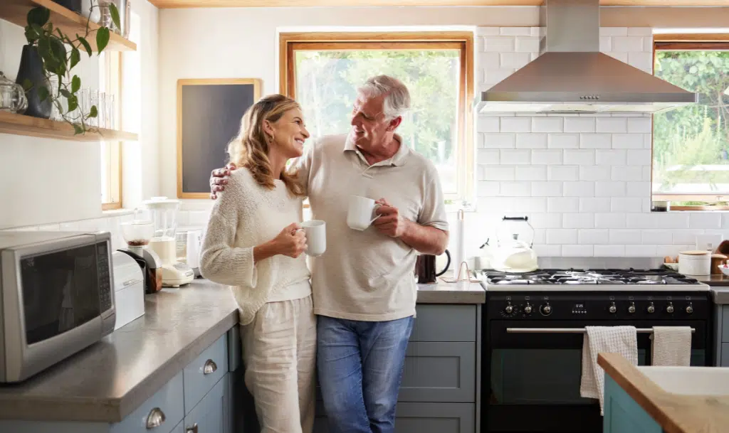 Man and woman in home drinking coffee.