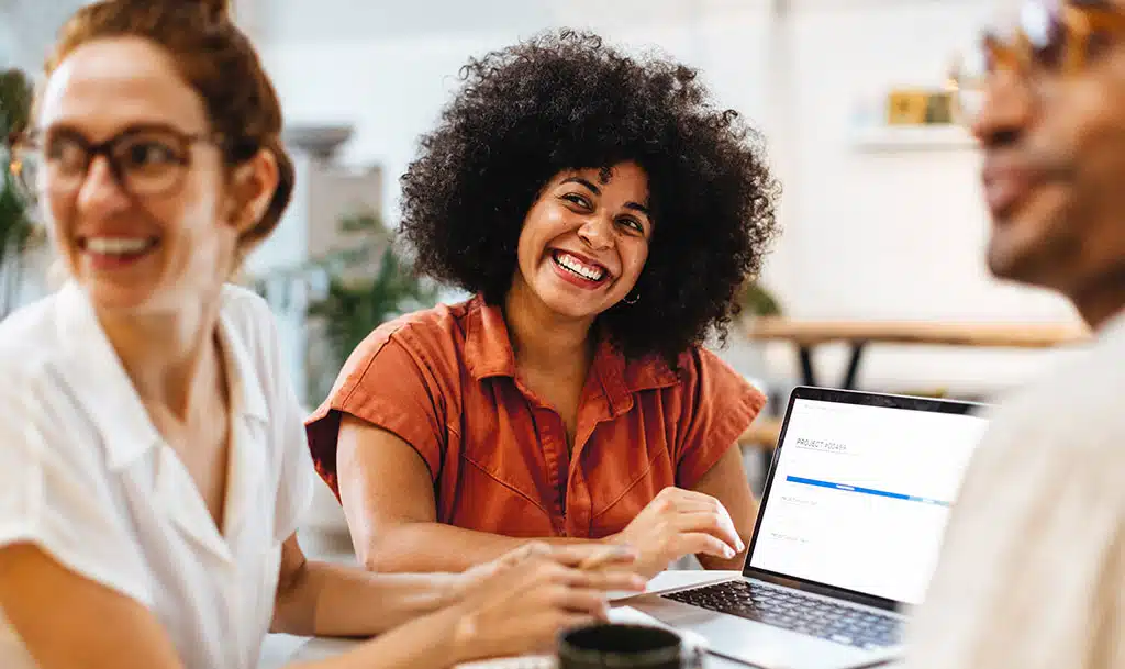 Picture of a smiling happy marketer with colleagues.